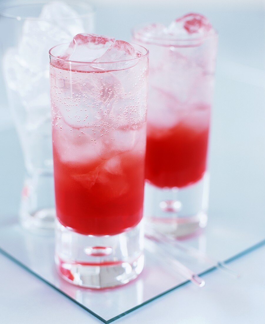 Red cocktails with soda water over ice