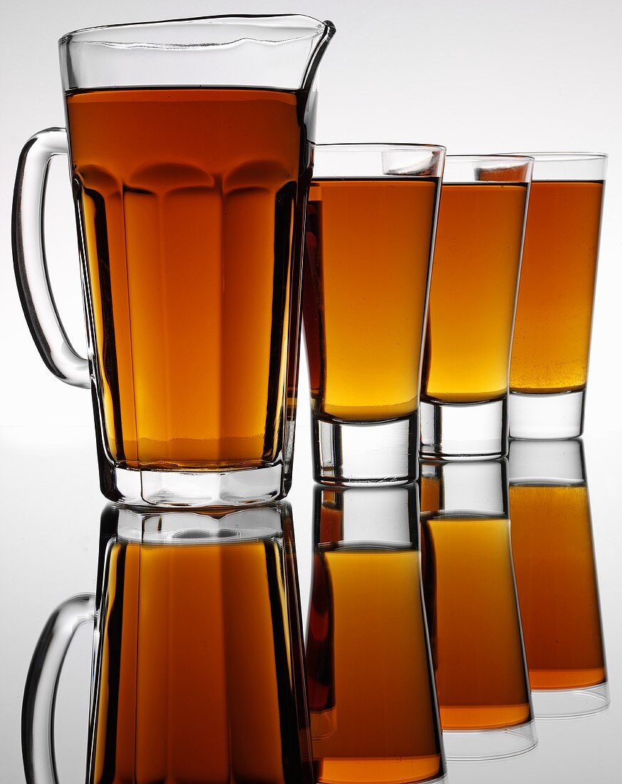 Root beer with sarsaparilla in jug and glasses