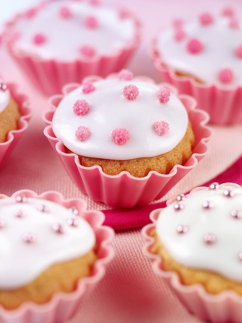 Cupcakes mit weisser Glasur und rosa Zuckerperlen