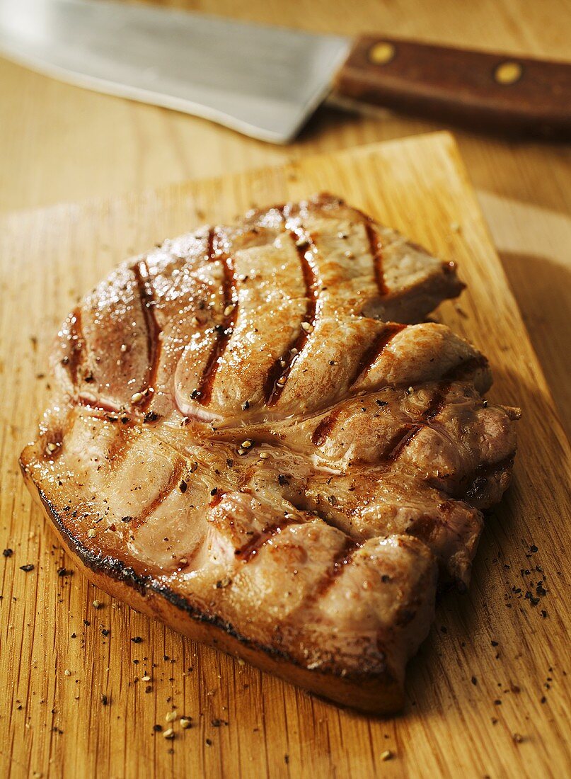 Grilled pork steak on chopping board