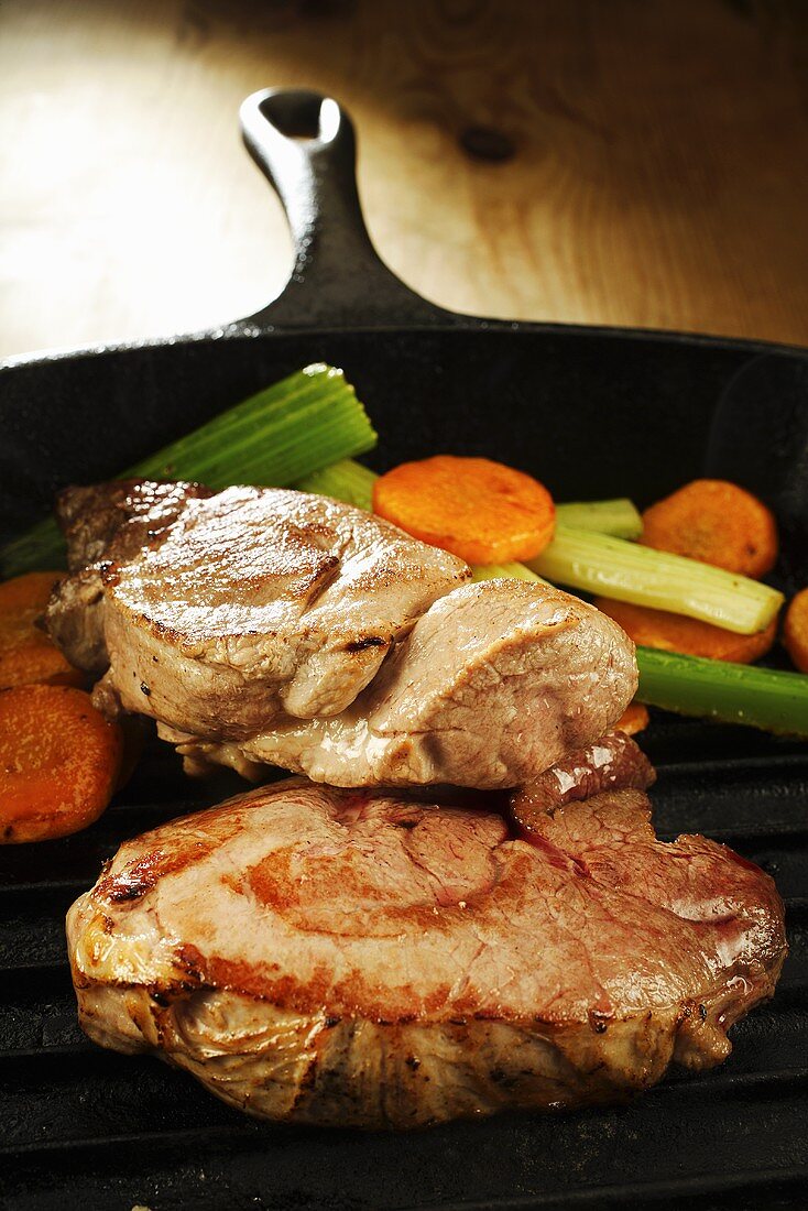 Wild boar steaks with vegetables in grill pan