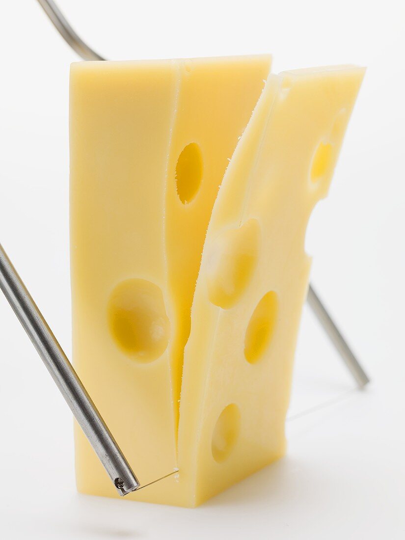 Cutting a slice of Emmental cheese