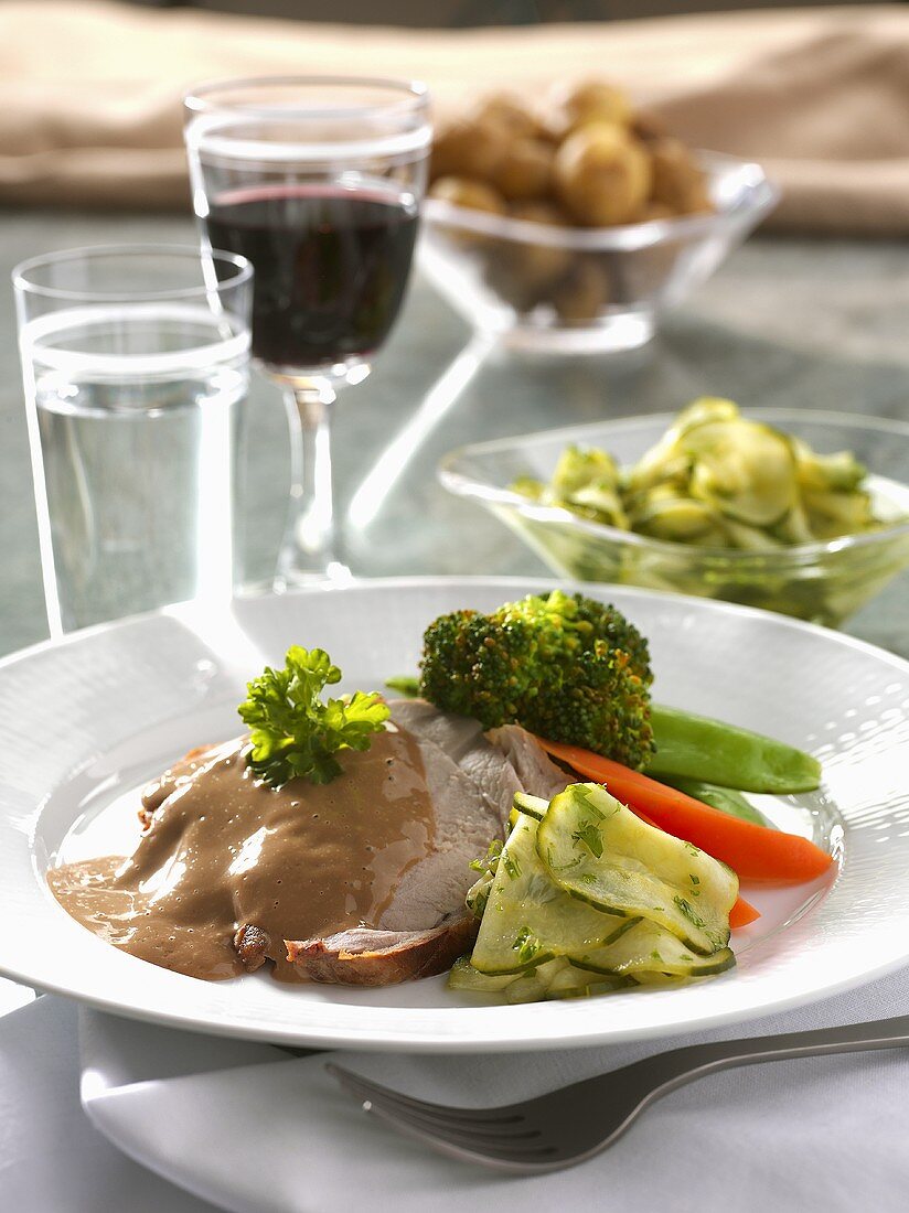 Pork steak with sauce, cucumber salad and vegetables