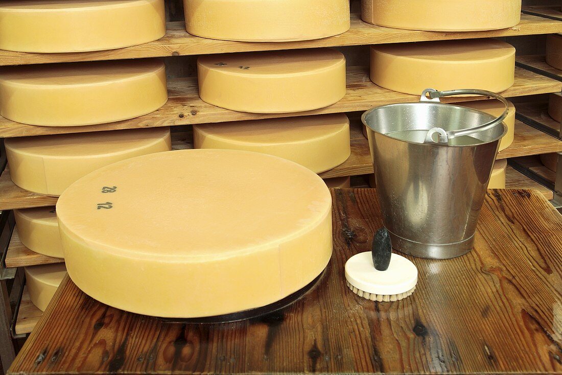 Bergkäse cheese (Alpine cheese) with bucket and brush