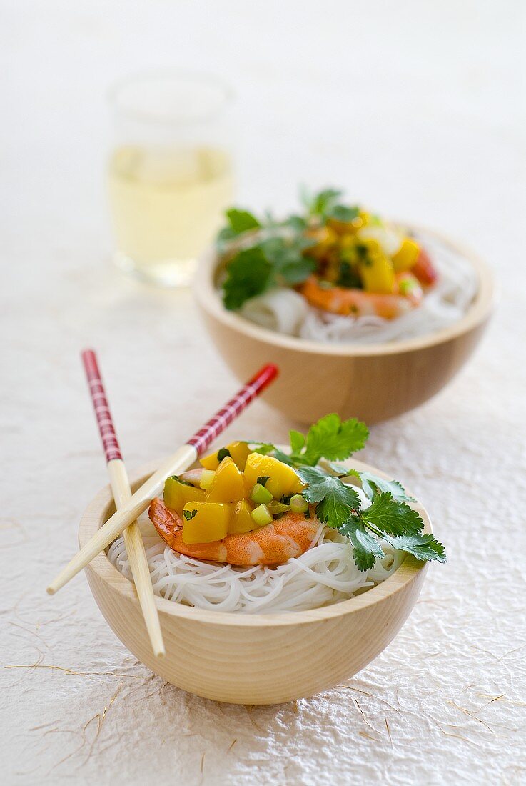 Two bowls of prawn and mango salad with rice noodles
