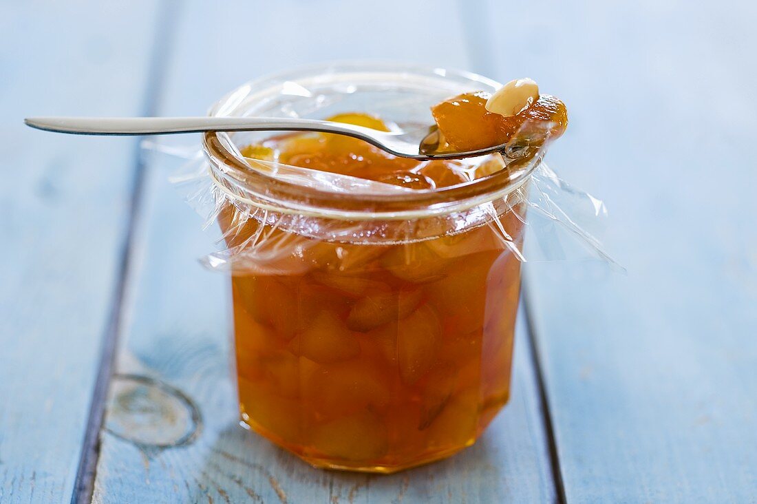 Aprikosenmarmelade mit Mandeln im Glas und auf Löffel