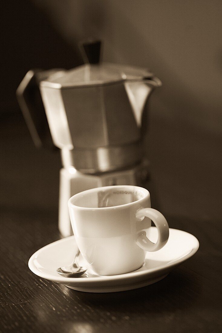 An espresso cup and saucer and espresso pot