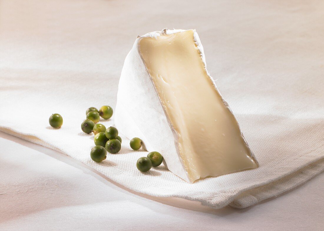 Ein Stück Brie mit grünem Pfeffer
