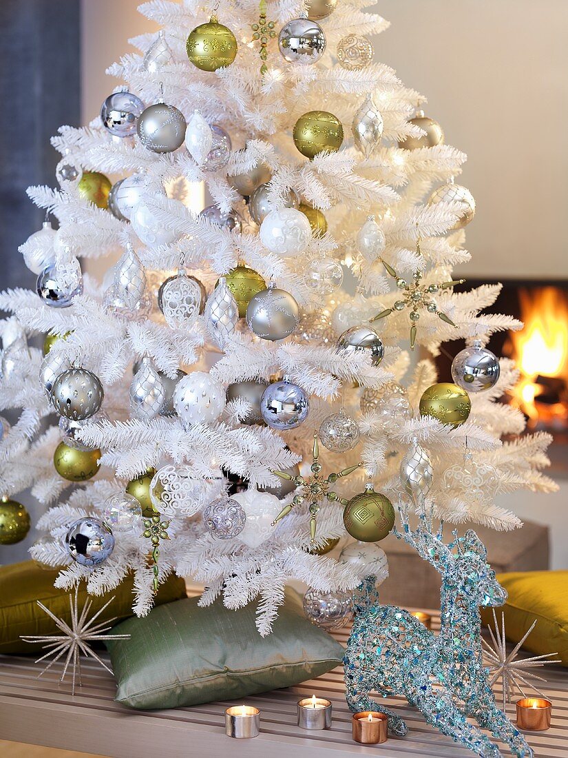 White artificial Christmas tree in front of open fire