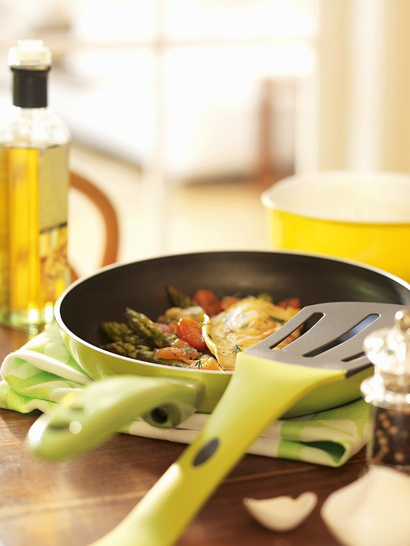 Asparagus and tomato omelette in frying pan