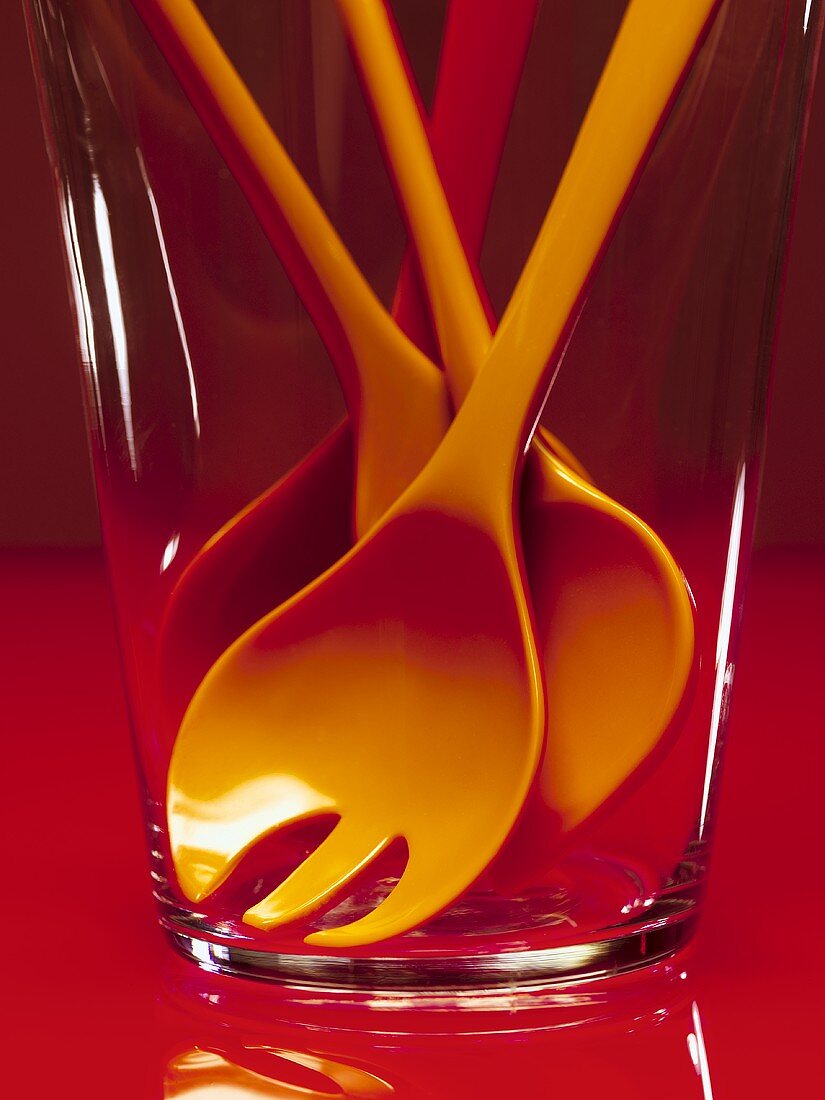 Cooking spoons (red and orange) in a glass