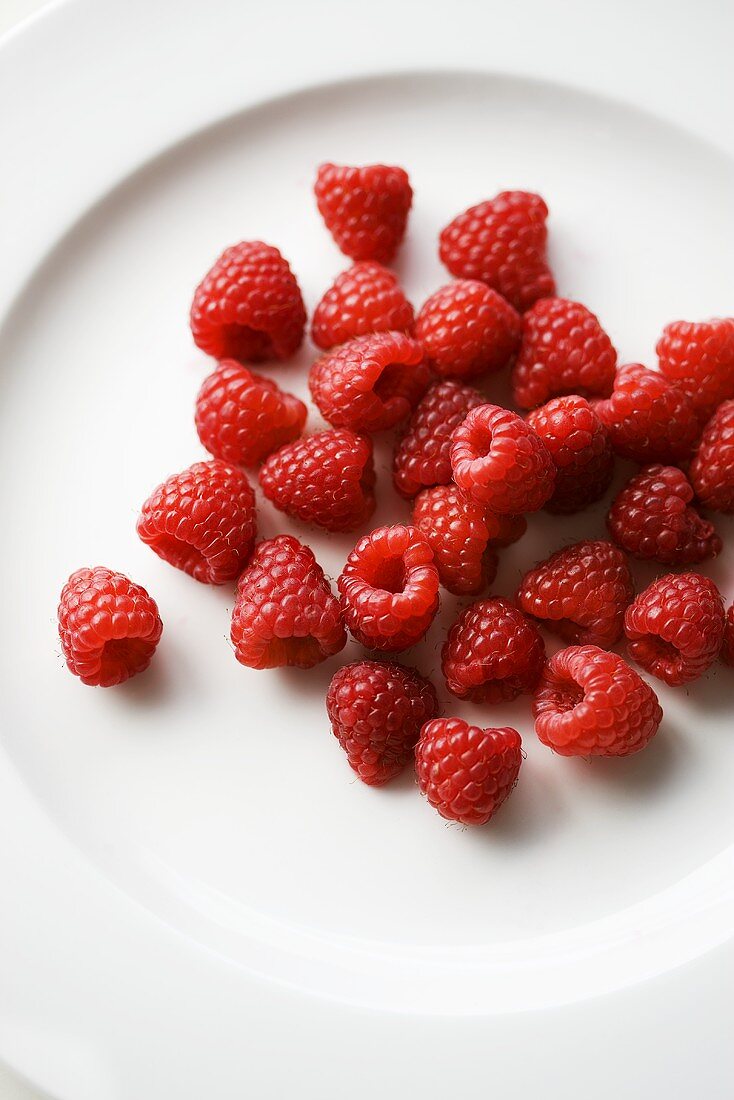 Fresh raspberries on plate (overhead view)