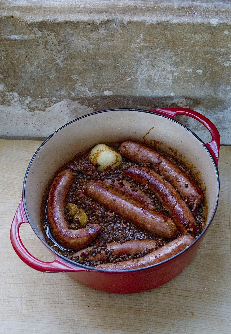 Pork sausages with lentils in a pan