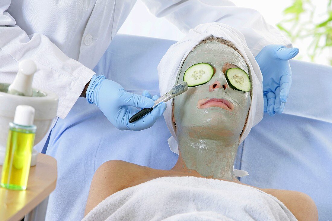 Woman in face mask having cosmetic treatment