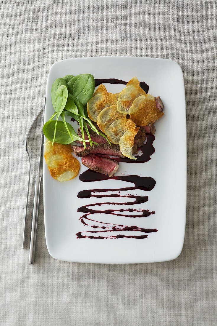 Rindersteak mit Kartoffelchips und Spinat