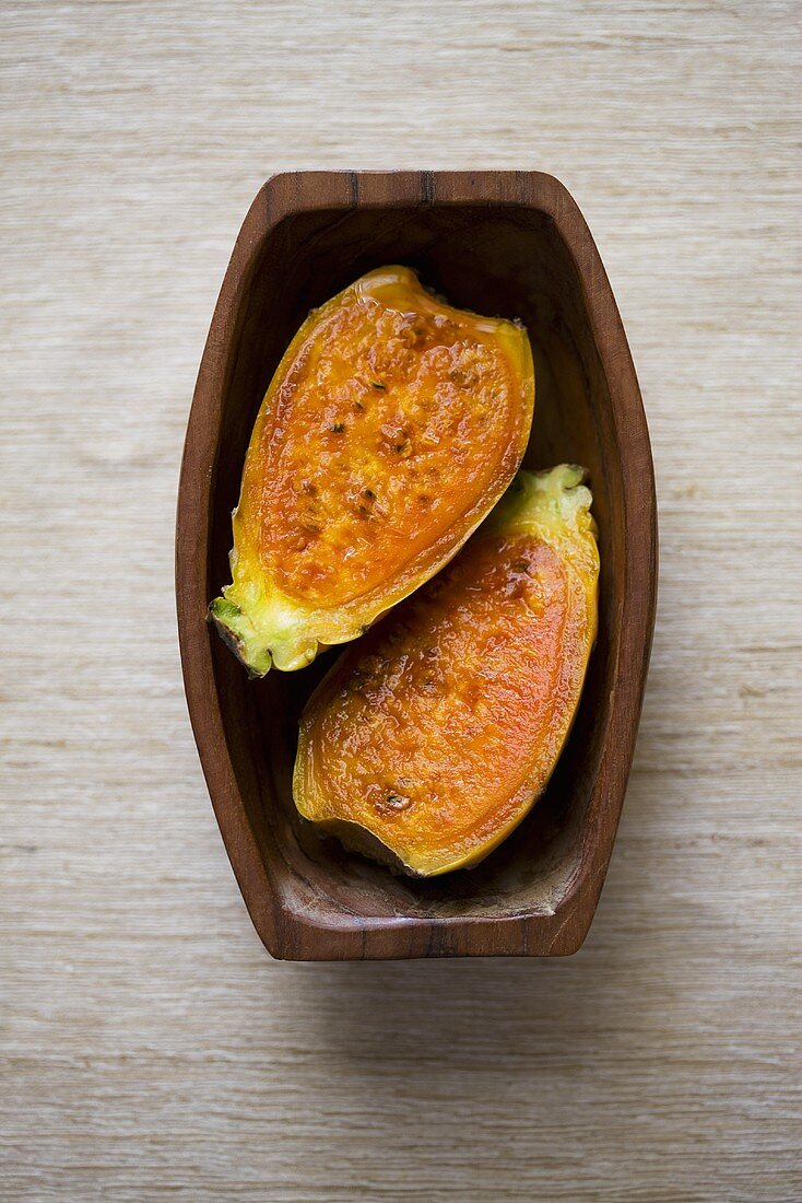 Prickly pear, halved, in wooden dish