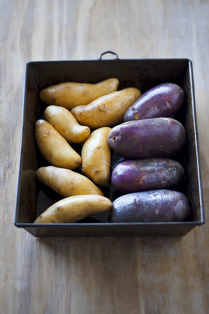 Potatoes and sweet potatoes in a roasting tin