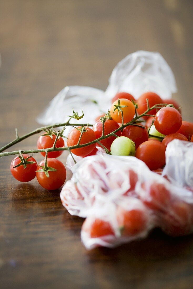 Tomatoes on the vine, some in plastic bag