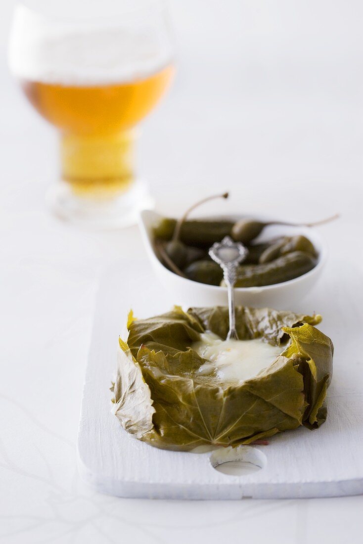 Stuffed Camembert wrapped in vine leaves, glass of beer