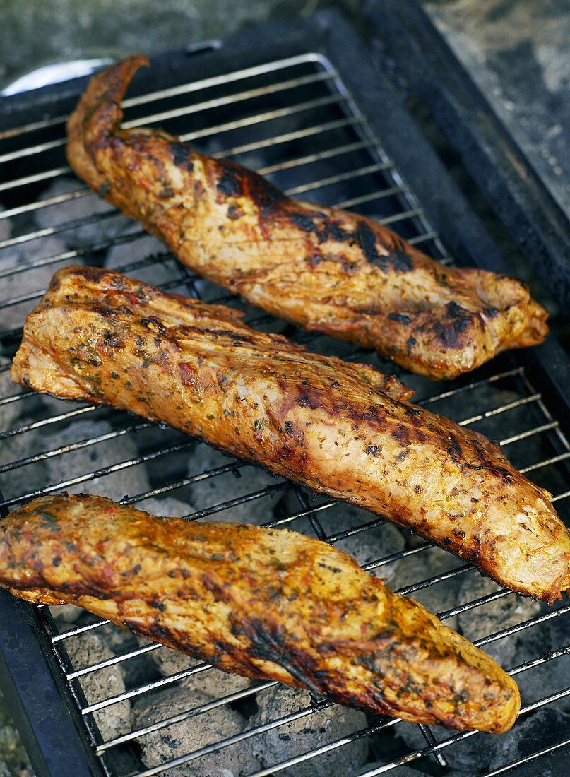 Three pork fillets on a barbecue