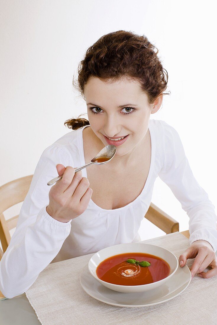 Junge Frau isst Tomatencremesuppe