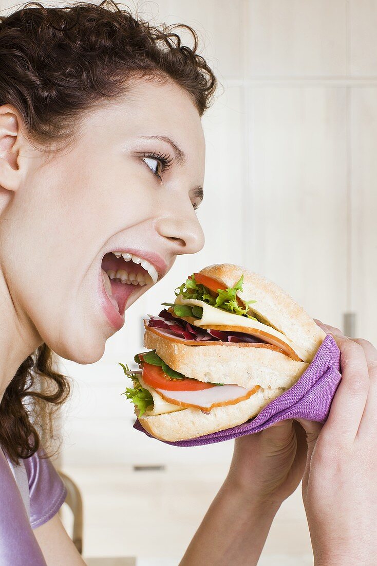 Young woman eating sandwich