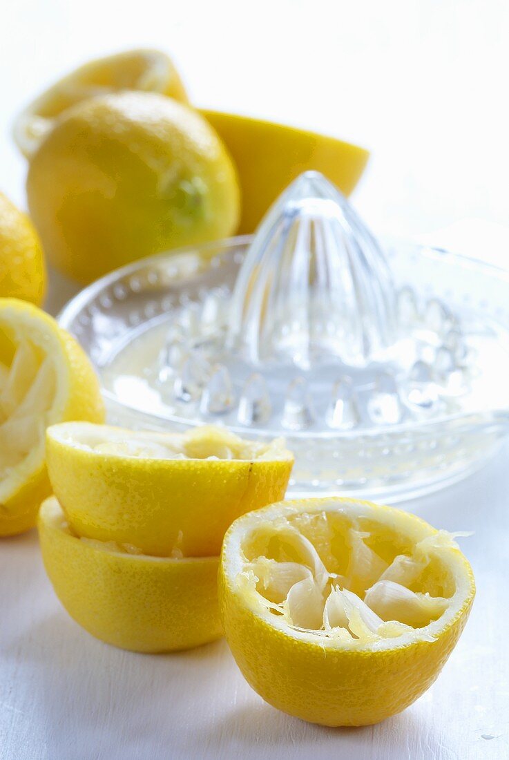 Ausgepresste Zitronenhälften mit Zitruspresse