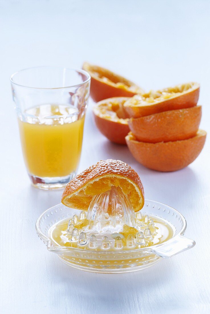 Zitruspresse, Orangenhälften & frisch gepresster Orangensaft