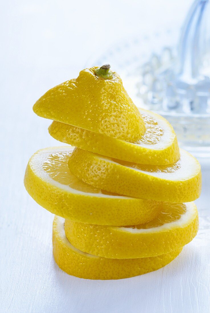 Stacked lemon slices, lemon squeezer in background