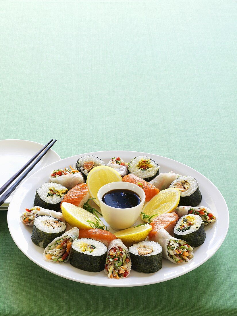 Assorted sushi and rice paper rolls on plate