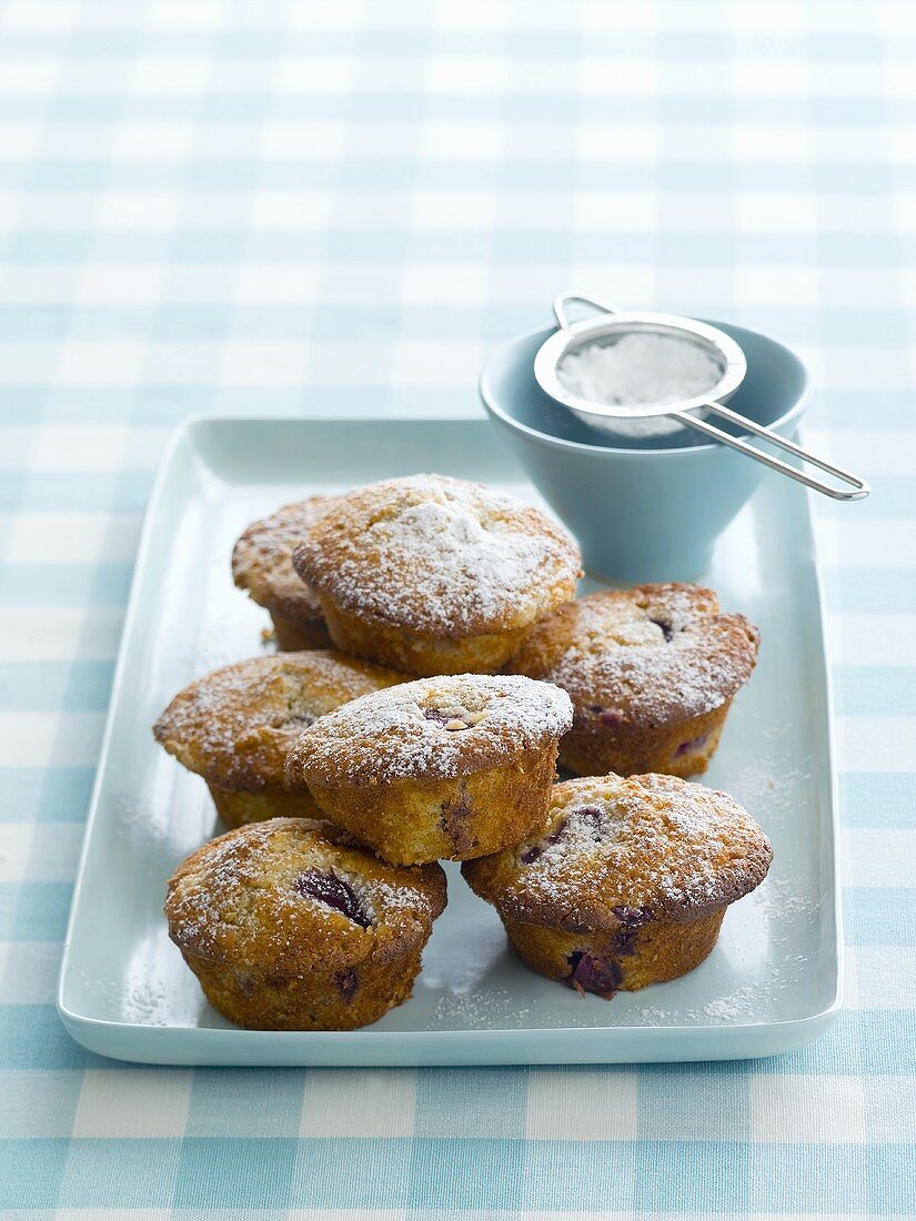 Plum muffins sprinkled with icing sugar
