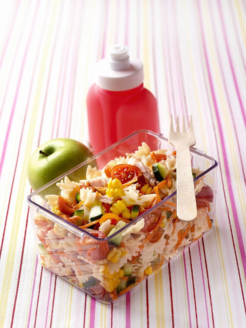 Farfalle with tuna and vegetables, apple, drinking bottle