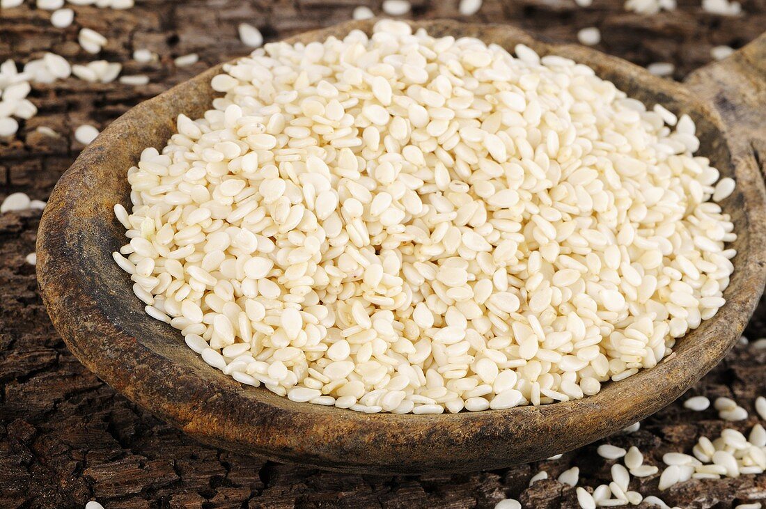 White sesame seeds on a wooden spoon