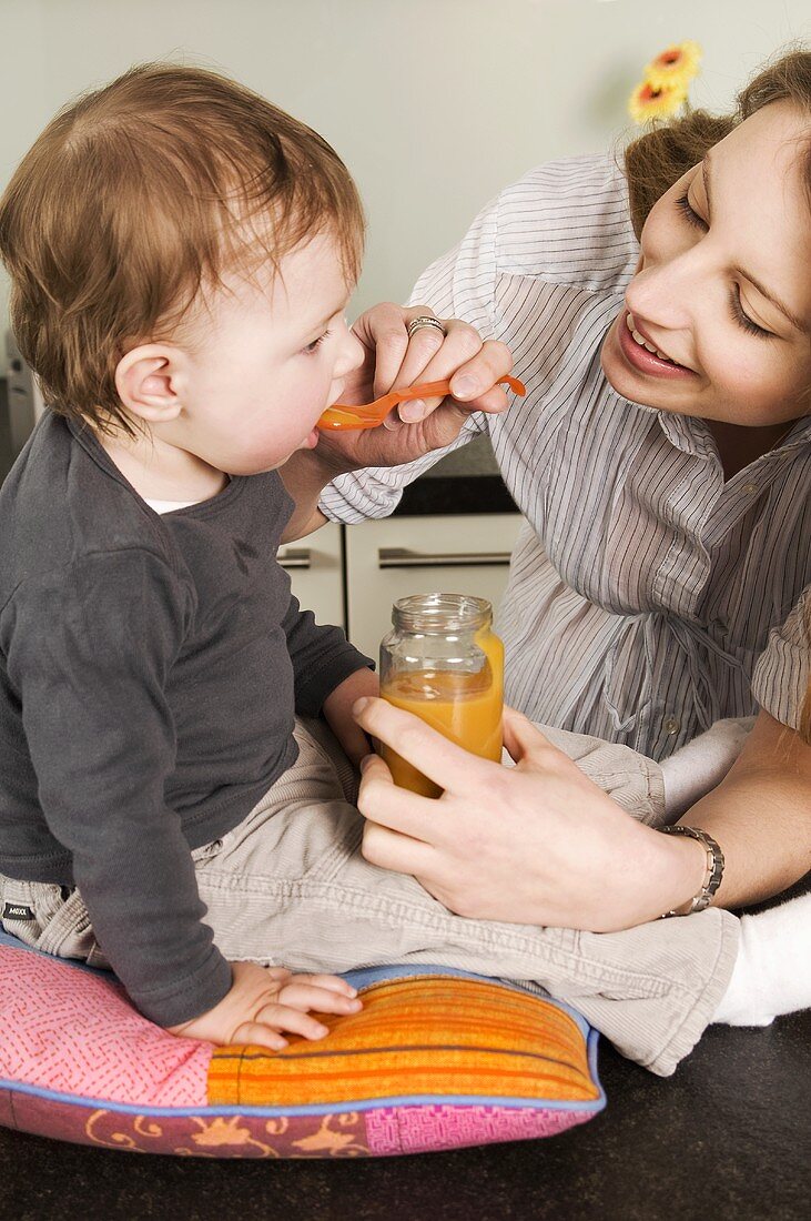 Toddler being fed baby food