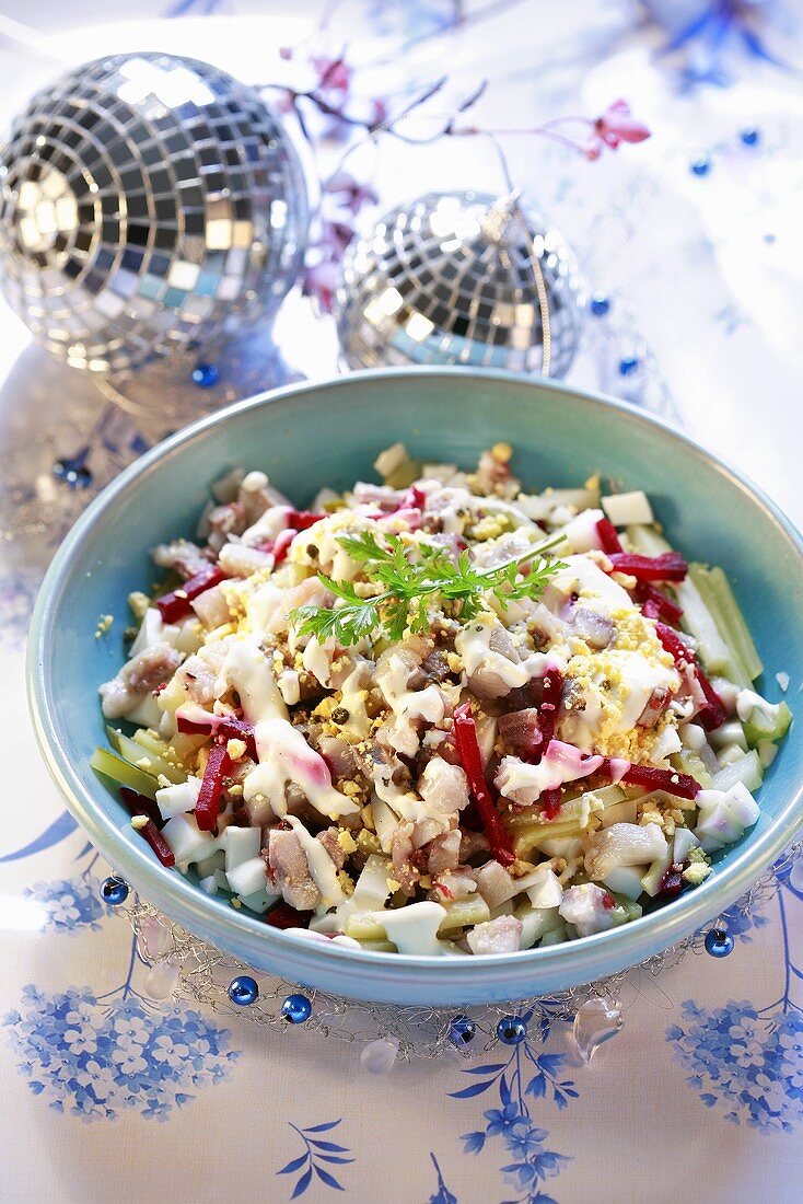 Herring salad in a pale blue bowl & two mirrored baubles