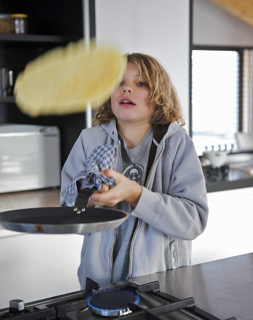 Boy tossing a wholemeal pancake