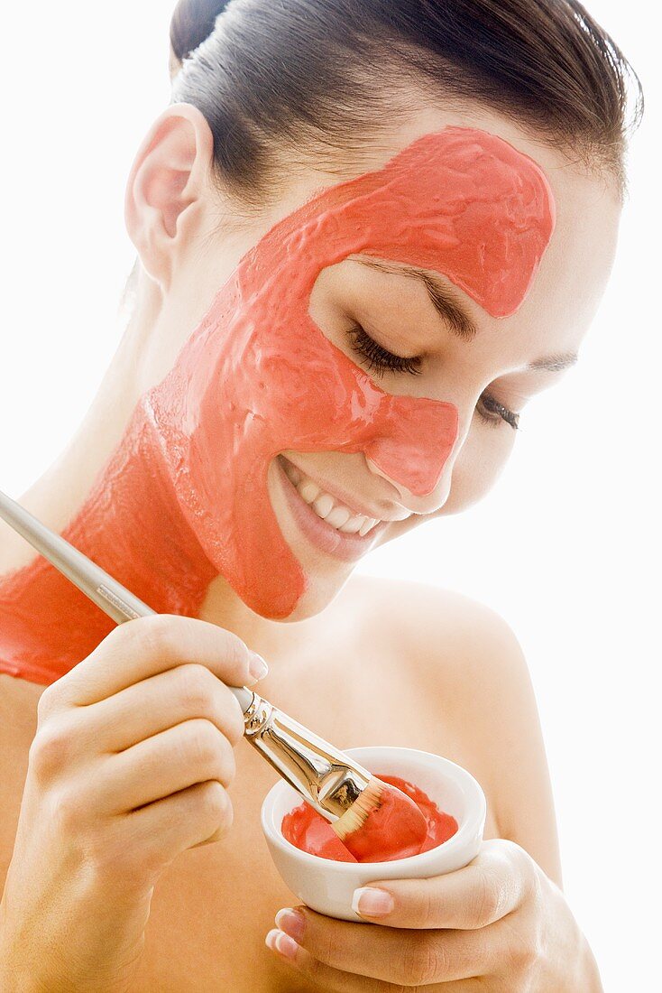 Junge Frau mit roter Gesichtsmaske