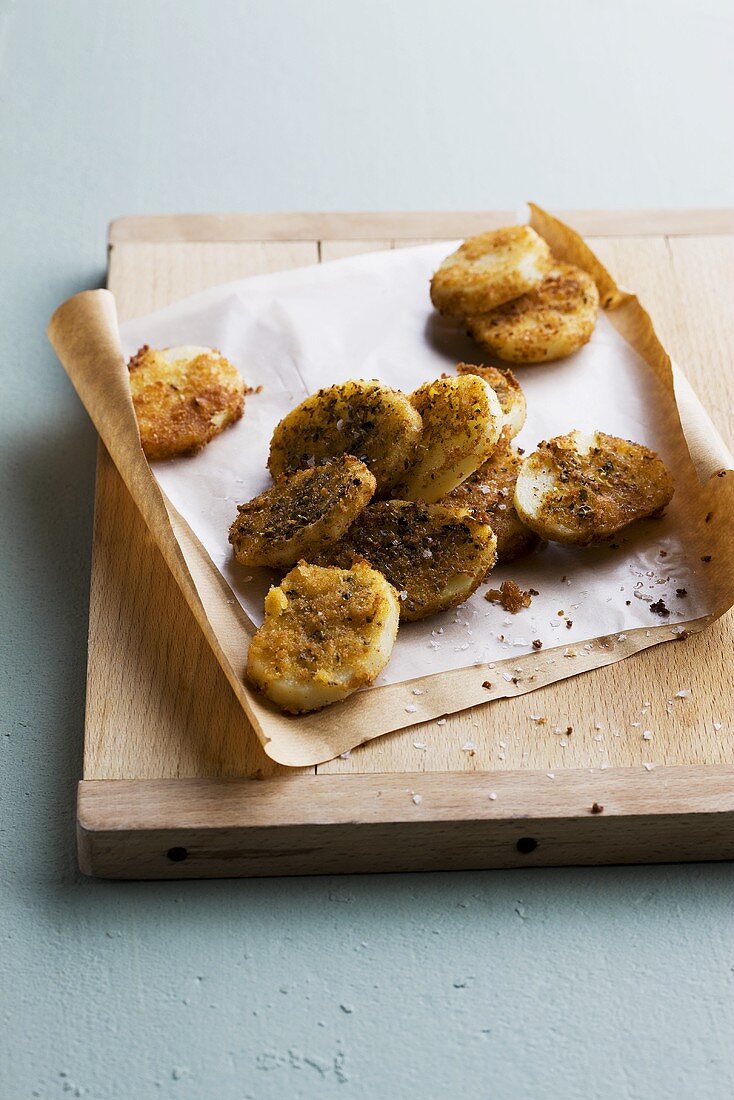 Spicy home-made potato crisps with sea salt on paper