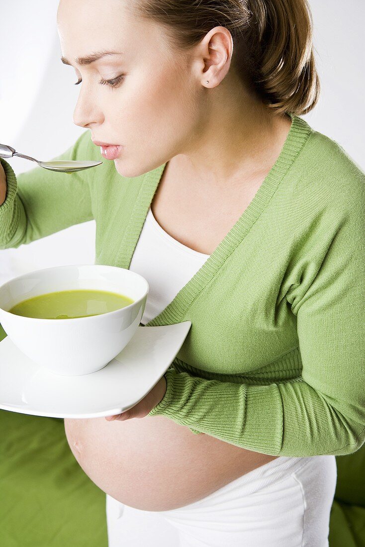 Schwangere Frau isst Gemüsecremesuppe