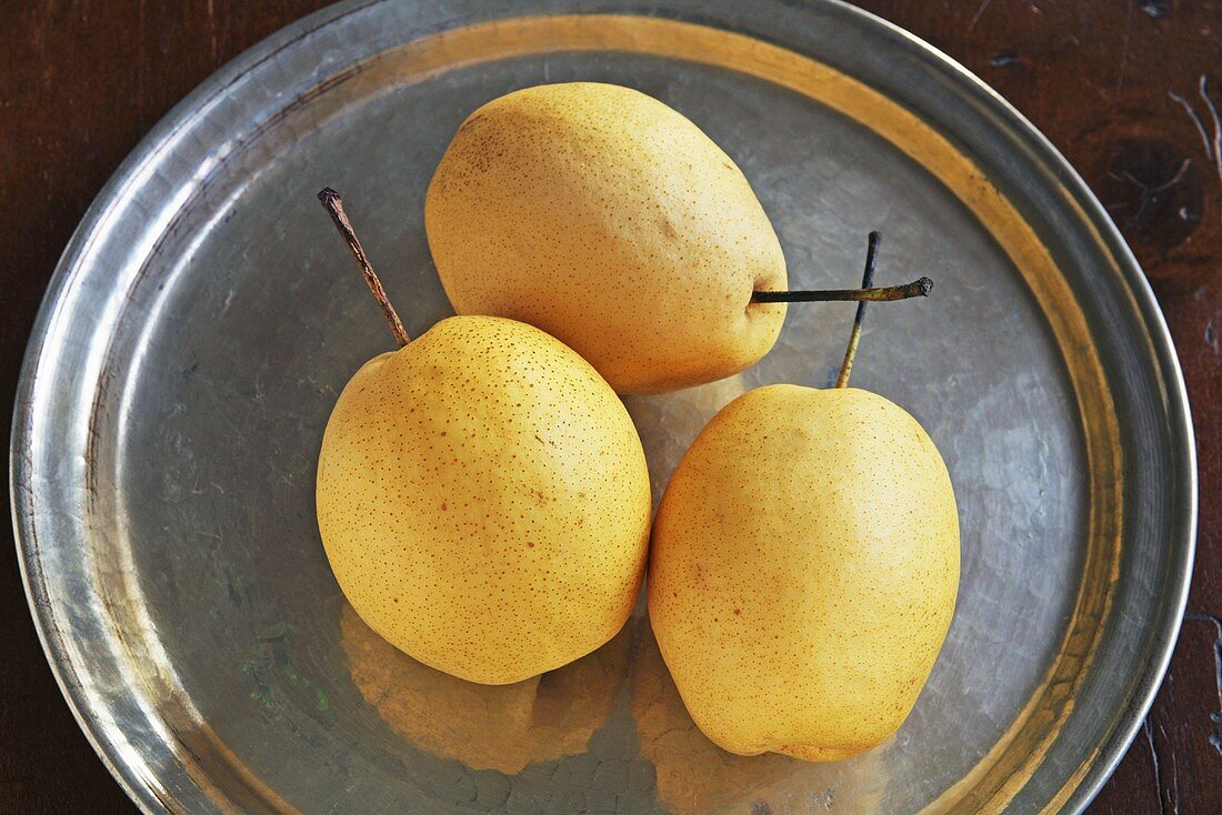 Three nashi pears on pewter plate