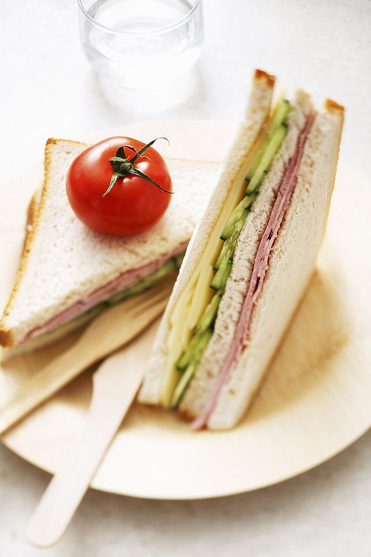 Ham, cheese and cucumber club sandwiches with tomato