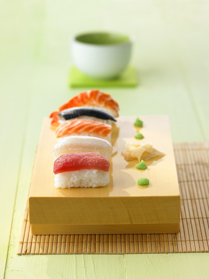Five nigiri sushi with wasabi and ginger
