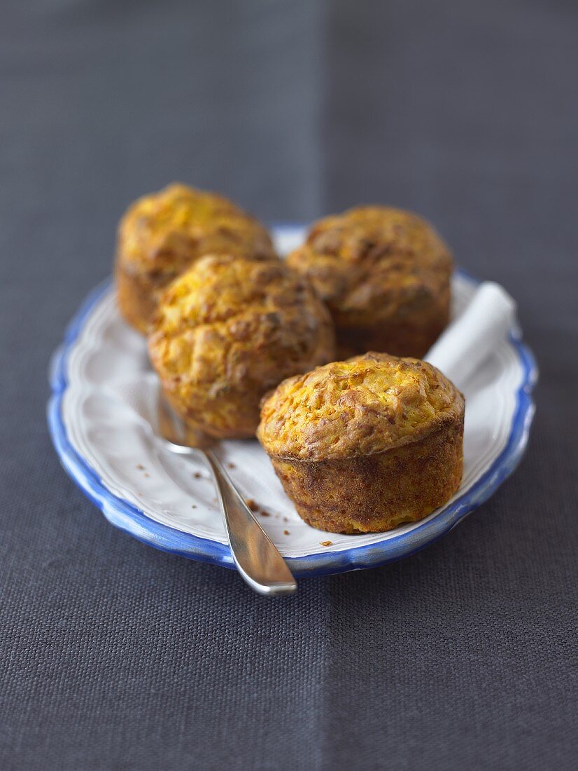 Four pumpkin muffins on a plate