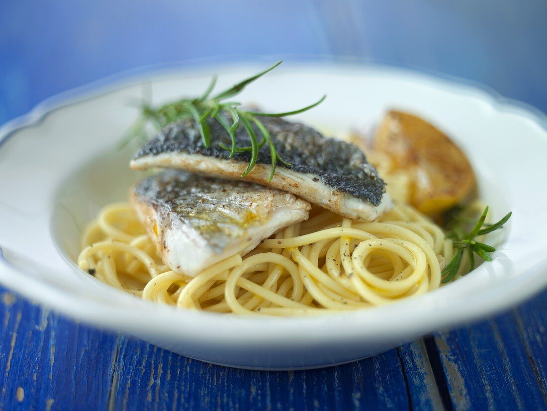 Fried sea bass on spaghetti with rosemary