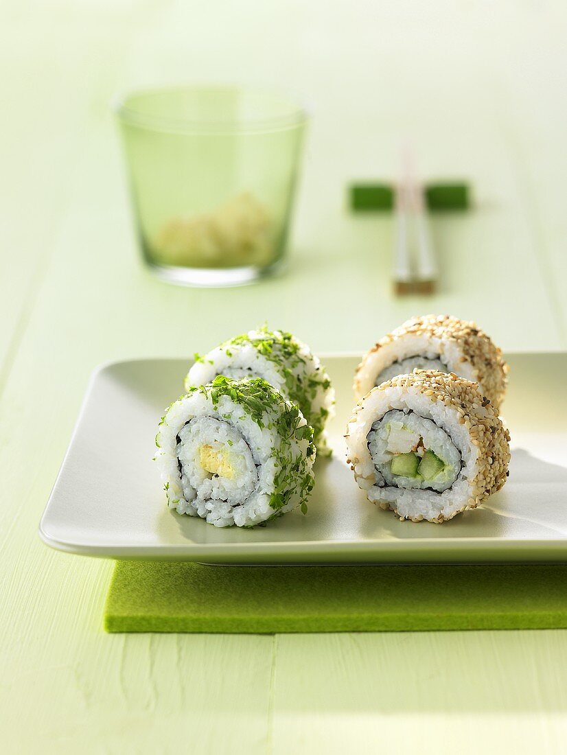 Four uramaki sushi with sesame seeds and coriander