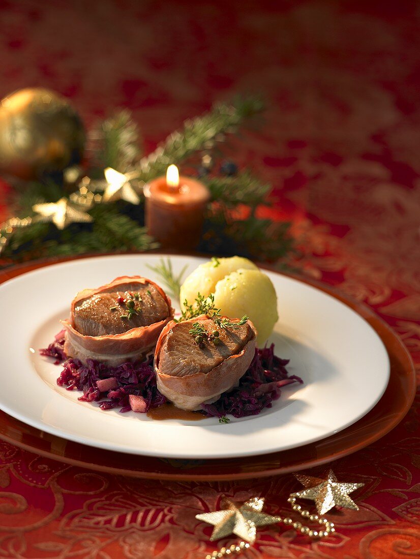 Bacon-wrapped pork fillet on red cabbage with potato dumpling