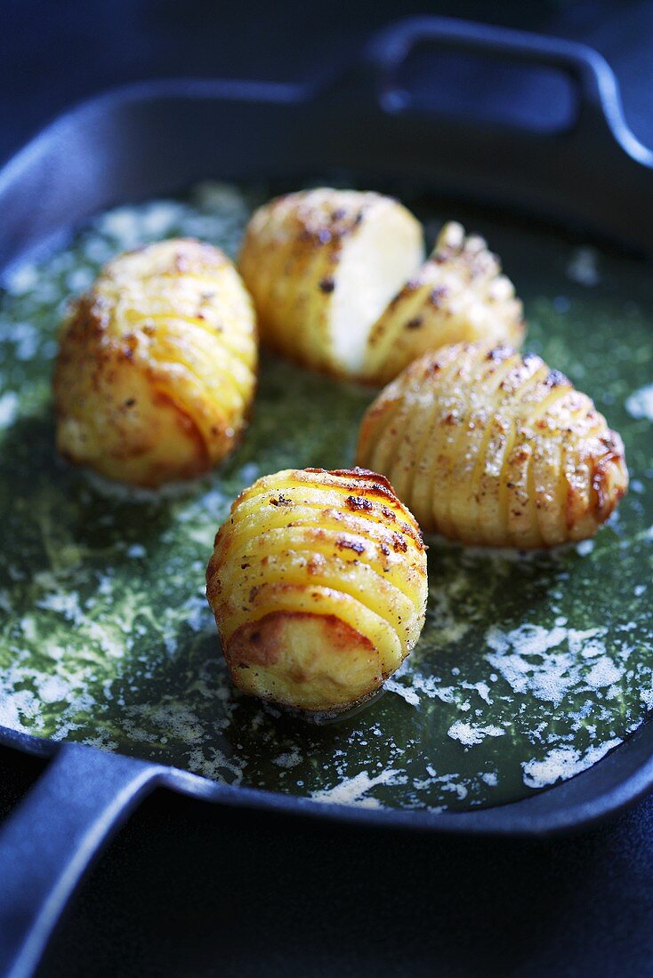 Hasselbackspotatis in a frying pan with butter