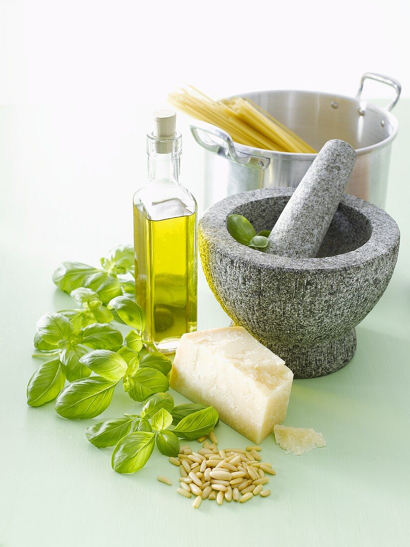 Ingredients for pesto, mortar and pestle, spaghetti in pan