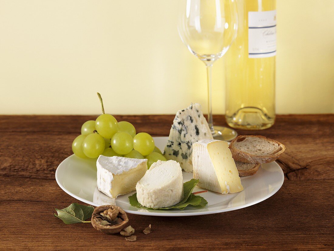 Cheese plate with grapes and bread, white wine