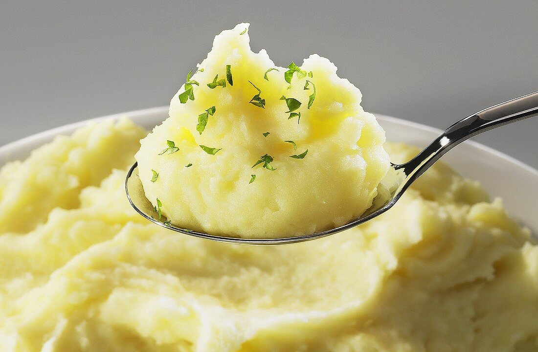Mashed potato on spoon and in bowl